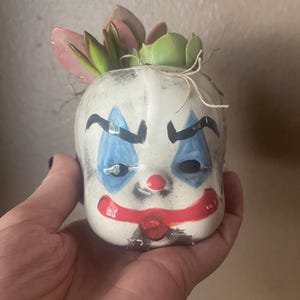 Vaso di fiori a forma di testa di pagliaccio inquietante