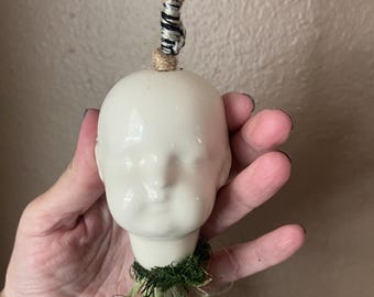 Creepy baby doll hanging air plant