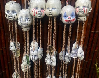 Campanillas hechas a mano con forma de cabeza de muñeca espeluznante