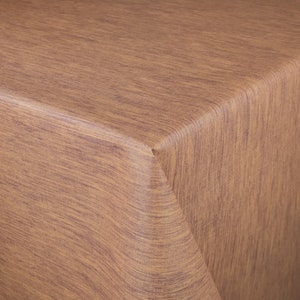 Può includere: Primo piano di una tovaglia marrone con un motivo a venature del legno. Il tessuto ha un aspetto strutturato con linee verticali nelle tonalità del marrone e del viola. L'angolo della tovaglia è visibile.