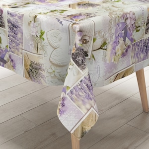 Könnte beinhalten: Rechteckige Tischdecke mit Patchwork-Design mit Lavendelzweigen, Blumen und Bildern im Vintage-Stil in Lila-, Weiß- und Beigetönen. Die Tischdecke ist über einem Holztisch drapiert.