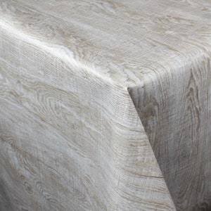 Könnte beinhalten: Nahaufnahme einer weißen Tischdecke mit Holzmaserung und texturierter Oberfläche.