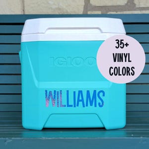 Puede incluir: Una nevera portátil Igloo de color turquesa con tapa blanca, que presenta el nombre WILLIAMS en una fuente iridiscente multicolor en la parte frontal. Un gráfico circular de color lila claro a la derecha muestra el texto negro 35+ VINYL COLORS.
