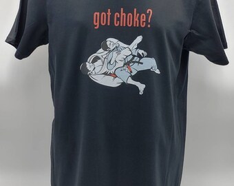 May include: Black t-shirt featuring a graphic of two people in a grappling hold, with the text "got choke?" in red. The design is a stylized illustration, suitable for martial arts enthusiasts.