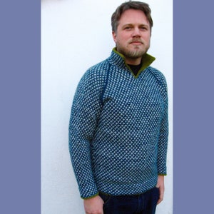 May include: A blue and white patterned sweater with a green collar and trim. The sweater has a high neckline and a zipper.