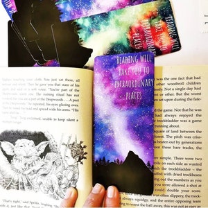 May include: A close-up of a book open to a page with text about a fictional world. The text reads "Reading will take you to extraordinary places". The page is decorated with a watercolour painting of a purple and blue night sky with stars and a mountain range in the distance.