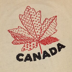 May include: Red embroidered maple leaf with a stitched pattern and the word "CANADA" in black lettering.