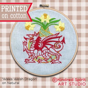 May include: Embroidered hoop art featuring a red Welsh dragon with yellow daffodils. The text 'Wales Welsh Dragon' and 'on Natural' is printed below the hoop. The text 'Kindred Spirit ART STUDIO' is printed in the lower right corner.
