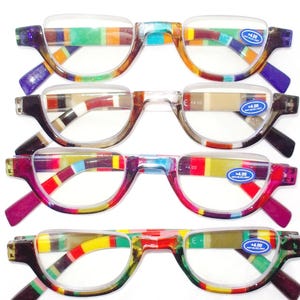Puede incluir: Cuatro pares de gafas de lectura de media montura con monturas a rayas coloridas. Las gafas tienen lentes transparentes y están marcadas con +4.00 y pegatinas de luz anti-azul. Las monturas presentan una mezcla de colores.