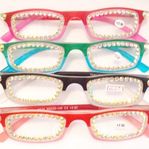 May include: Four pairs of reading glasses with rhinestone embellishments. The frames are in various colors: red and pink, green and blue, black and clear, and red and pink. Each pair has a +3.50 magnification.