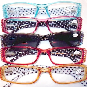 May include: An assortment of reading glasses in various colors, including blue, pink, and red. Each pair features a decorative frame and a +2.00 magnification. The lenses are clear, and the arms have a polka dot pattern.