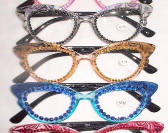 May include: Five pairs of cat-eye reading glasses with rhinestones around the frames. The glasses are in pink, gray, gold, blue, and red. Each pair has a different strength, indicated by a sticker on the right lens: +2.50, +2.75, +1.75, +2.50, +1.75.