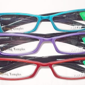 Op de afbeelding: Drie paar leesbrillen met strasssteentjes op de pootjes. De brillen zijn in turquoise, paars en rood. Elk paar heeft een groen label met de tekst " +2.25 18" en de tekst "Spring Temples" aan de binnenkant van de monturen.