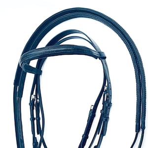 May include: A dark blue leather horse bridle with a browband, noseband, and reins. The bridle has silver buckles and stitching.