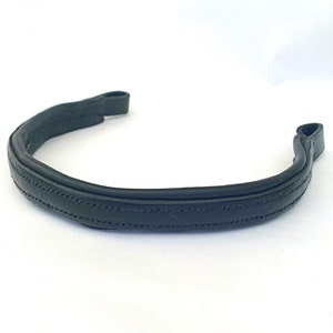 May include: A black leather browband for a horse bridle. The browband has a stitched design.