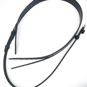 May include: A black leather belt with a buckle and multiple holes for adjusting the fit.