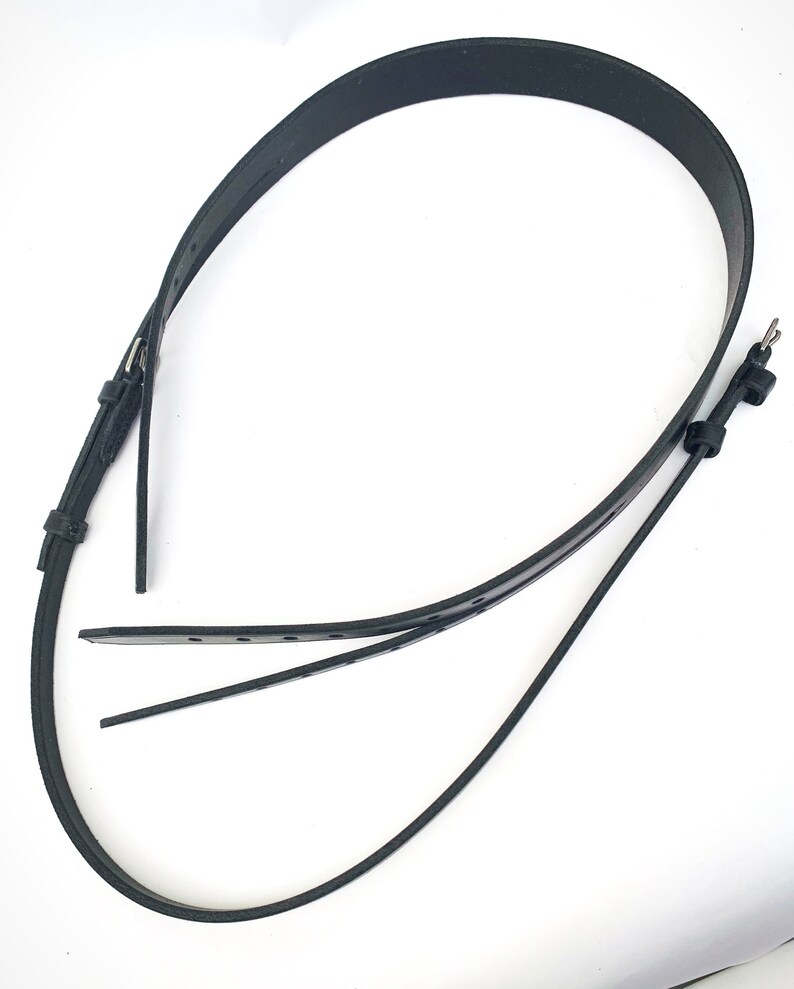 May include: A black leather belt with a buckle and multiple holes for adjusting the fit.