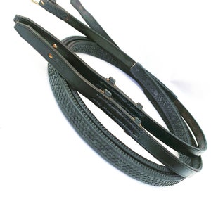 May include: Two black leather reins with a textured rubber grip. The reins are folded in half and are ready for use.
