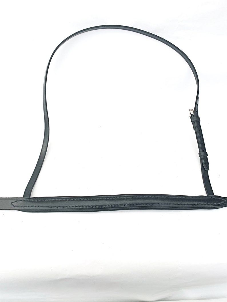 May include: Black leather horse bridle rein with a stitched edge and a brass buckle.