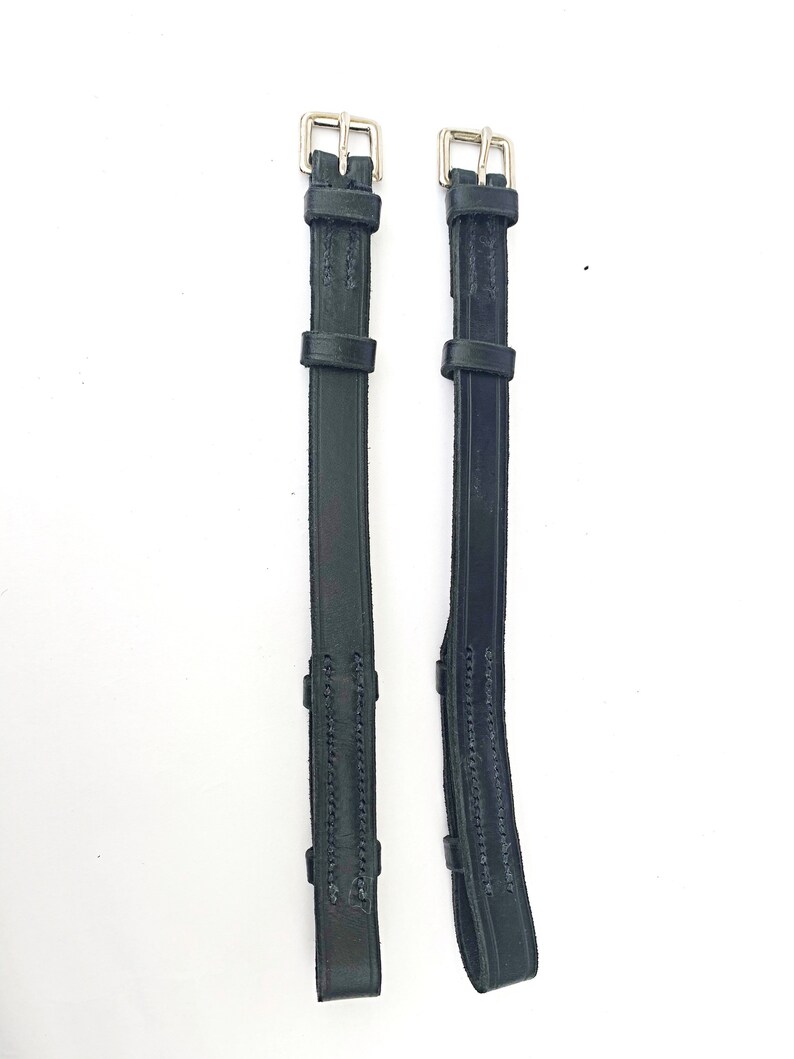 May include: Two black leather stirrup leathers with silver buckles.