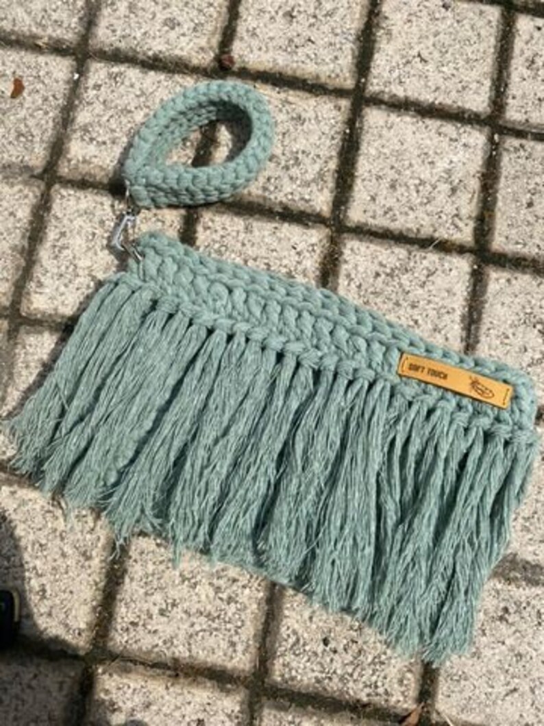 May include: A light green crocheted bag with fringe and a brown leather tag that says "Soft Touch".