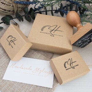 Tan colored gift boxes with shop logo and text in black ink. Hand stamped with the words "HandmadeStylings," on top of boxes.