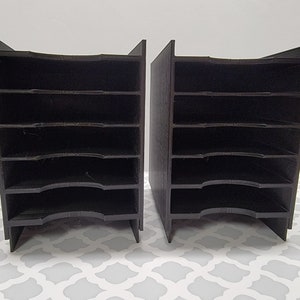 May include: Two black plastic storage organizers with six compartments each. The organizers are stacked on top of each other.