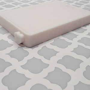 May include: A white plastic rectangular box with a small heart-shaped knob on the side.