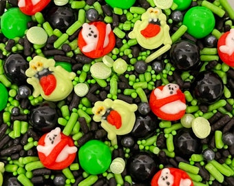May include: A bowl of green, black, and silver sprinkles with red and green ghost-shaped candies.
