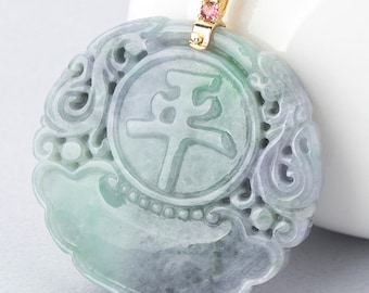 May include: A jade pendant with a carved Chinese character for peace, surrounded by intricate floral designs. The pendant is attached to a gold chain with pink gemstones.