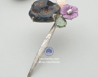 Könnte beinhalten: Ein silberner Haarstecker mit floralem Design. Der Stecker ist mit einem dunklen Achat-Stein, einer rosa Blume, einem grünen Blatt und zwei grünen Edelsteinen verziert. Der Stecker ist mit dem Text "naschenka.com @nas.naschenka" graviert.