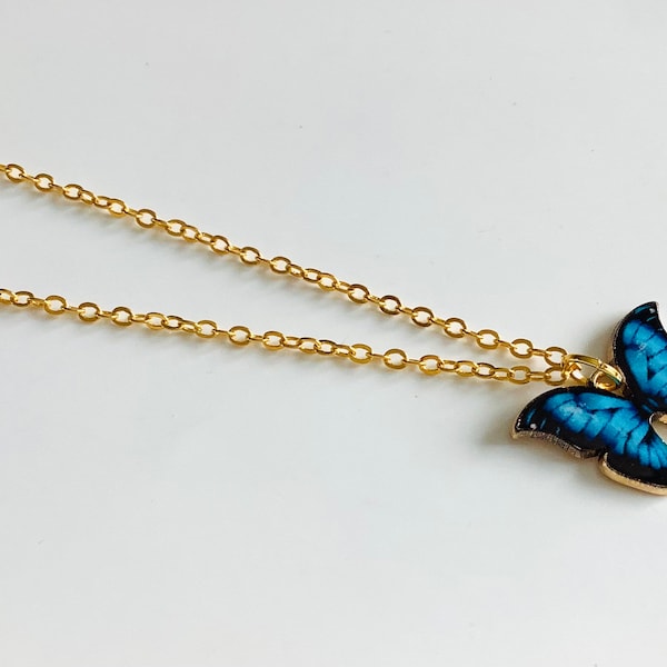 Gold colored necklace with blue butterfly