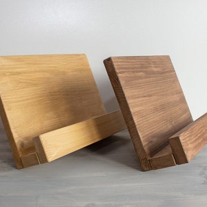 K&ouml;nnte beinhalten: Zwei Holzbuchst&uuml;tzen, eine in nat&uuml;rlicher Holzoptik und die andere in dunkelbrauner Farbe. Beide Buchst&uuml;tzen haben ein schlichtes, rechteckiges Design mit einer schr&auml;gen Vorderkante zum Halten von B&uuml;chern.
