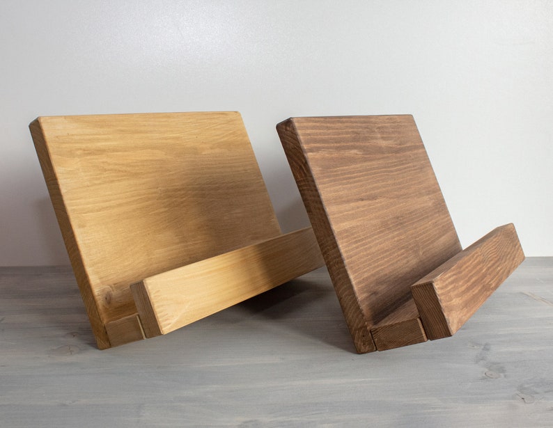 K&ouml;nnte beinhalten: Zwei Holzbuchst&uuml;tzen, eine in nat&uuml;rlicher Holzoptik und die andere in dunkelbrauner Farbe. Beide Buchst&uuml;tzen haben ein schlichtes, rechteckiges Design mit einer schr&auml;gen Vorderkante zum Halten von B&uuml;chern.