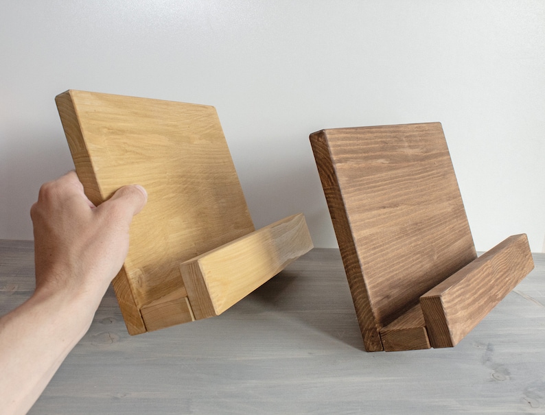 K&ouml;nnte beinhalten: Zwei Holzbuchst&uuml;tzen, eine hellbraun und eine dunkelbraun, mit einem schr&auml;gen Design, um B&uuml;cher aufrecht zu halten.