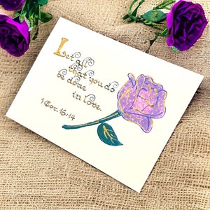 Cartões elegantes com versículos bíblicos vintage – 1 Coríntios 16:14, feitos à mão com detalhes em rosa púrpura e dourado, perfeitos para casamentos