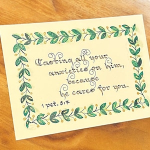 Elegante postal con versículo bíblico caligrafiada a mano 1 Pedro 5:7 en cartulina premium con detalles dorados