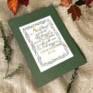 Arte bíblico atemporal caligrafiado a mano de 1 Corintios 6:14: elegante diseño vintage con reflejos dorados en una tarjeta martillada de alta calidad