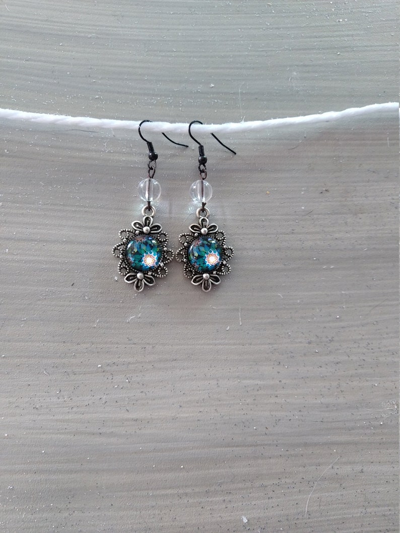 Fancy cabochon earrings with blue and green floral motof transparent pearl silver metal
