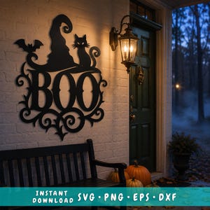 May include: A black metal wall sign featuring the word BOO in large capital letters, topped with a witch hat, a sitting cat, and a small bat silhouette. The design includes decorative scrollwork accents and is displayed on a white brick wall.