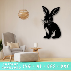 May include: A black silhouette of a rabbit sitting on a white background. The rabbit has long ears and a fluffy tail. The image is perfect for a craft project or a home decor accent.