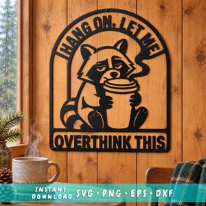 May include: A black metal wall sign featuring a stylized raccoon holding a coffee cup with steam rising. The arched frame includes the text HANG ON, LET ME OVERTHINK THIS. The design is a flat, cutout silhouette with bold, clean lines and lettering.