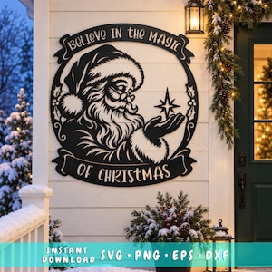 May include: A black circular metal wall sign featuring a detailed illustration of Santa Claus holding a star. The text "BELIEVE IN THE MAGIC OF CHRISTMAS" is arched along the top and bottom borders. The design includes holly leaf accents.