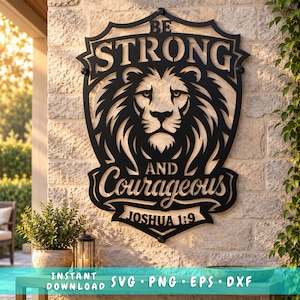Pode incluir: Uma placa de parede de metal preto em forma de escudo com uma ilustração de uma cabeça de leão no centro. O texto diz BE STRONG AND COURAGEOUS JOSHUA 1:9. A placa está montada numa parede de pedra clara com um design de borda decorativo.