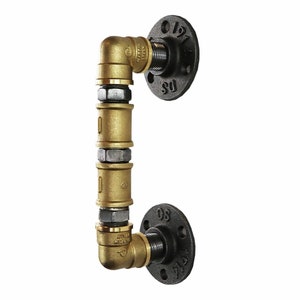 May include: A black and gold industrial pipe door handle with two flanges. The handle is made of metal and has a rustic look.