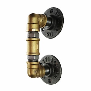 May include: A gold pipe fitting with black flanges. The flanges are marked with the numbers "1 1/2" and "1 1/4".