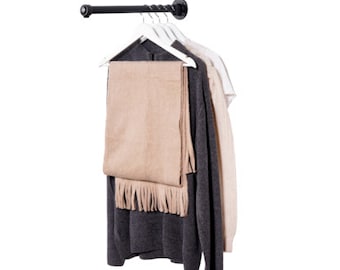 May include: A black metal clothing rack with a swivel arm, holding a grey sweater, a beige scarf, and white hangers.
