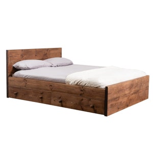 Puede incluir: Un marco de cama de madera con cabecera y dos cajones. La cama est&aacute; hecha de madera natural y tiene un aspecto r&uacute;stico.