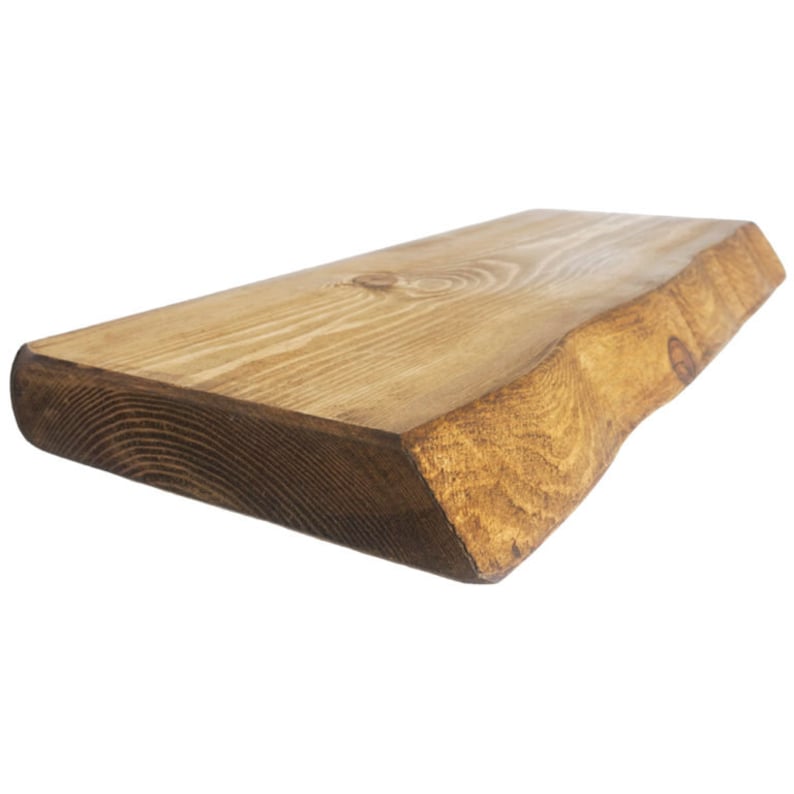 May include: A rustic wooden shelf with a natural edge and a dark brown stain. The shelf is made from a single piece of wood and has a unique, organic shape.