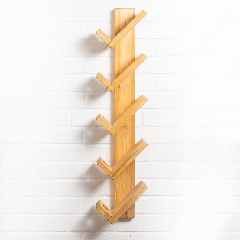 Op de afbeelding: Een houten wandplank met vijf schuine planken. De planken zijn gemaakt van natuurlijk hout en hebben een lichtbruine afwerking.